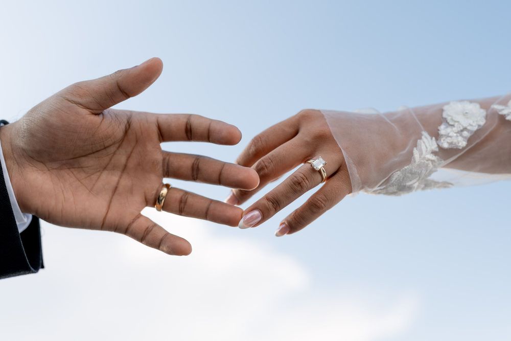 bride and groom touching hands during a candid moment