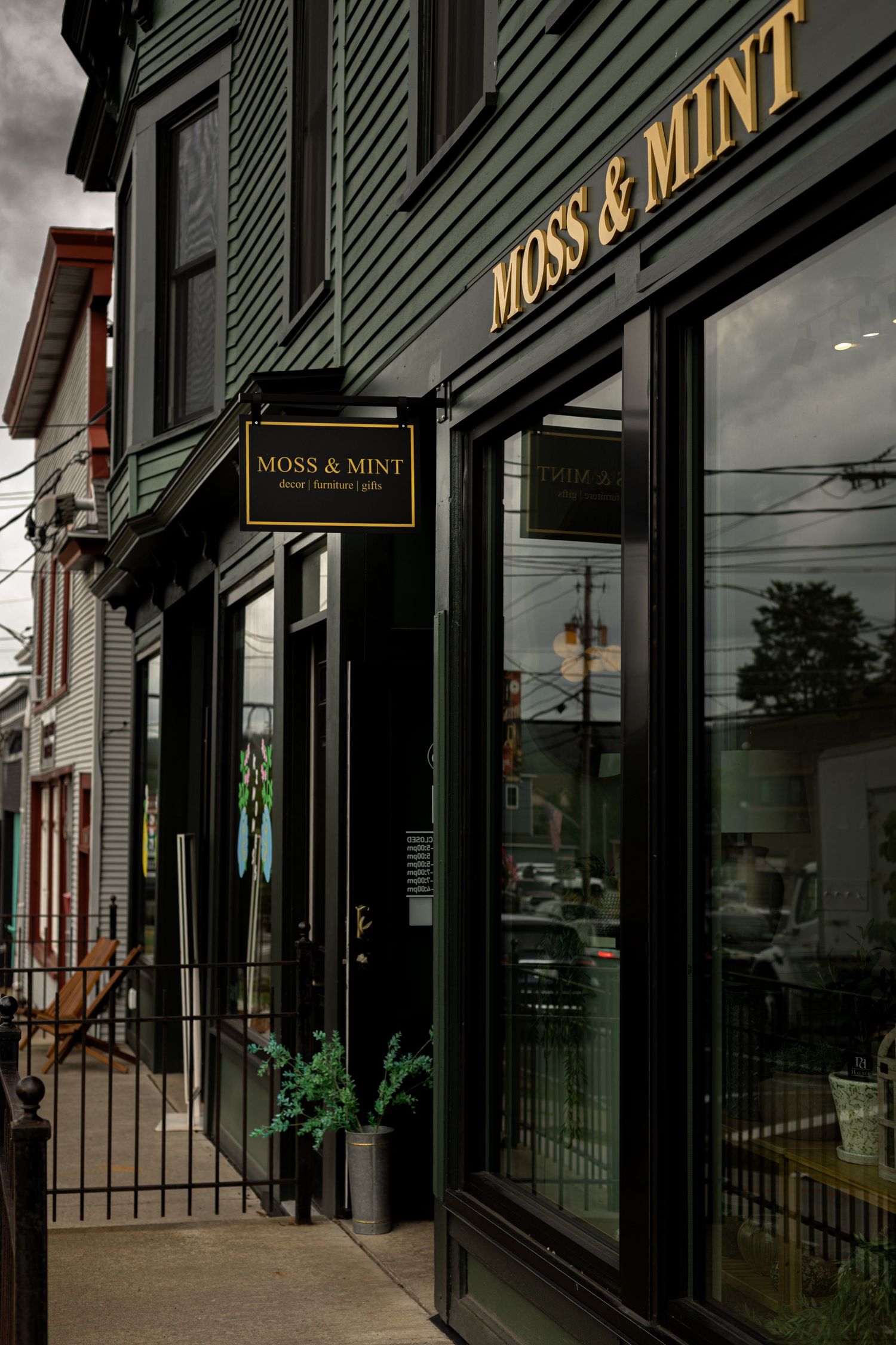 Moss & Mint boutique storefront with dark green exterior, gold signage, and large windows.