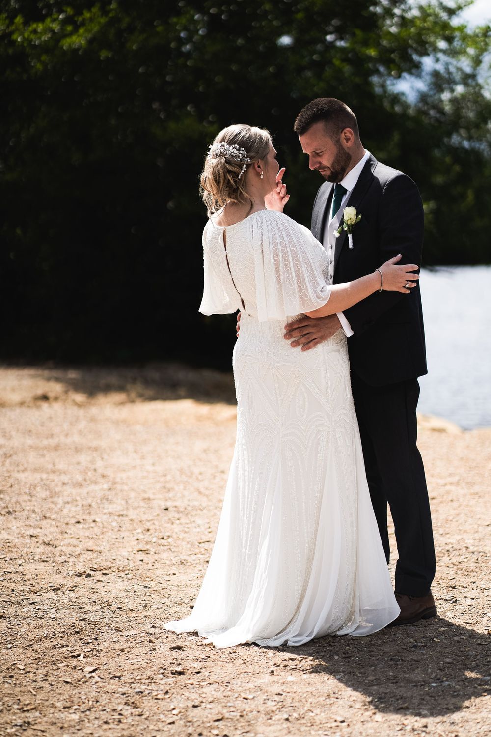 A romantic wedding sequence of a couple sitting together on a sandy beach in formal wedding attire.