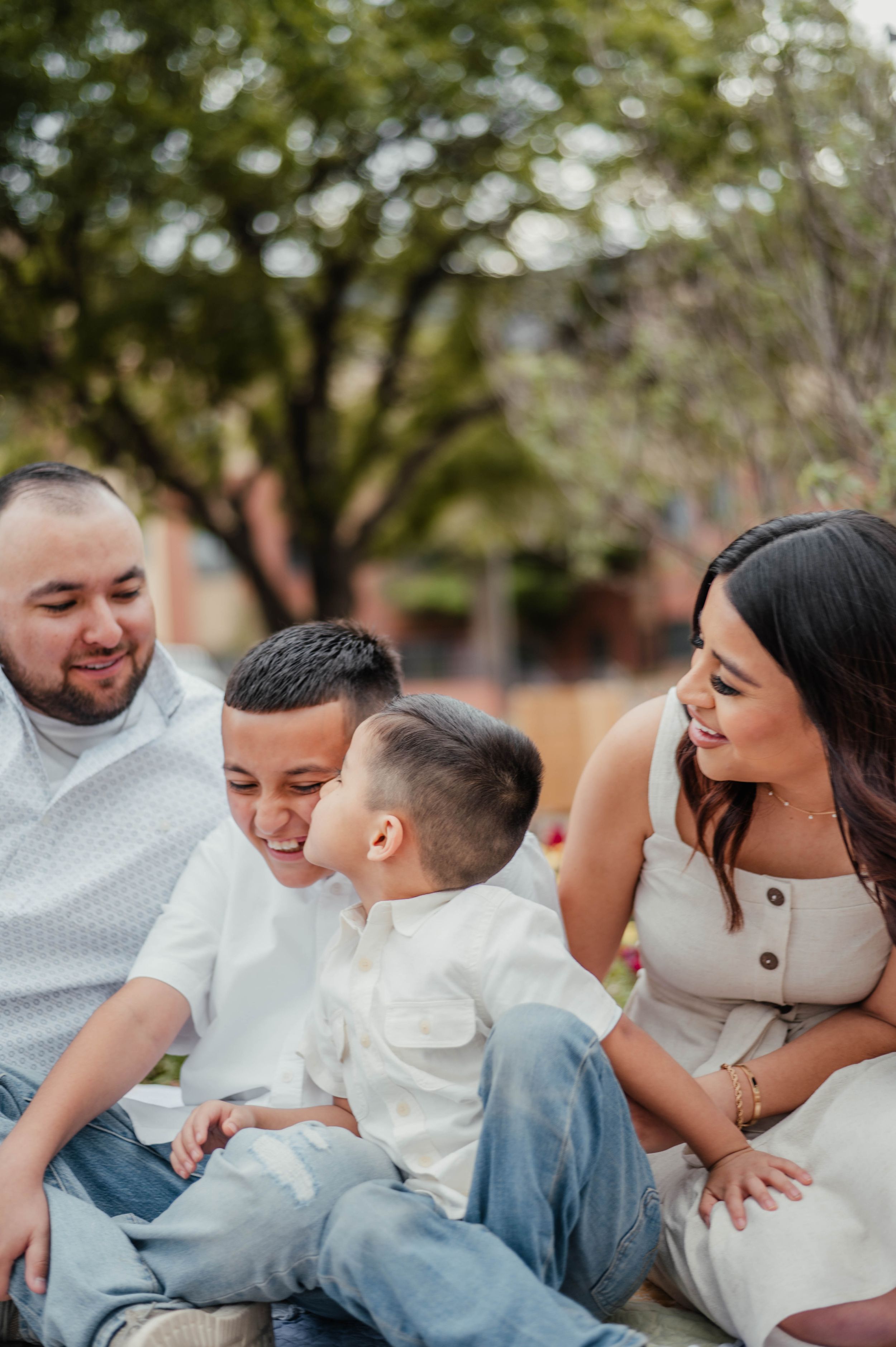A family shares a joyful moment together while sitting outdoors.