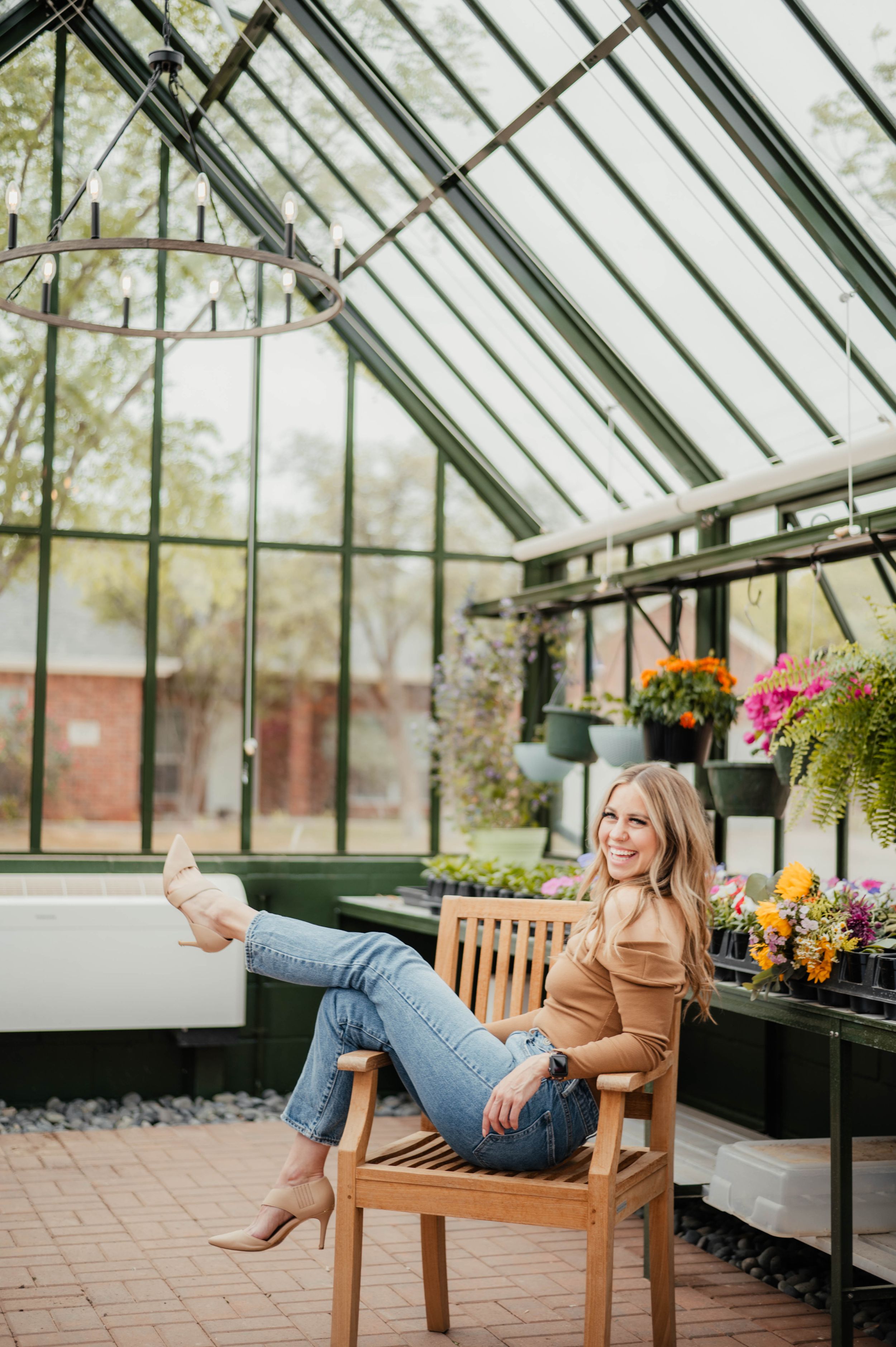 A relaxed greenhouse scene with someone lounging in casual attire among flowers.