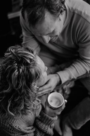 Intimate black and white photograph showing tender moment over coffee.