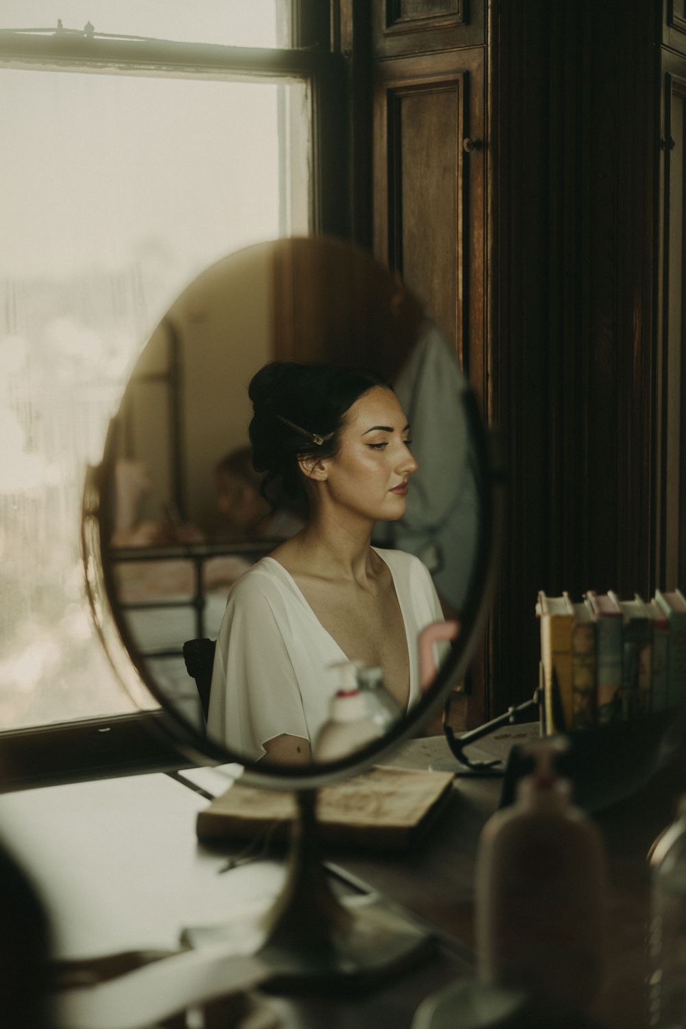 Atmospheric mirror reflection in vintage-style wedding preparation scene.