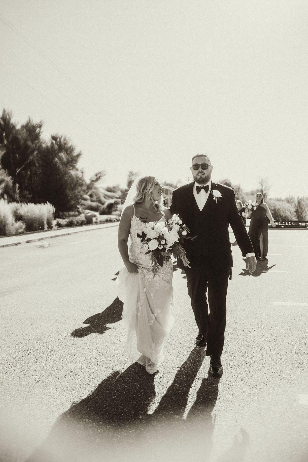 Black and white wedding photos showing couple walking together outdoors.