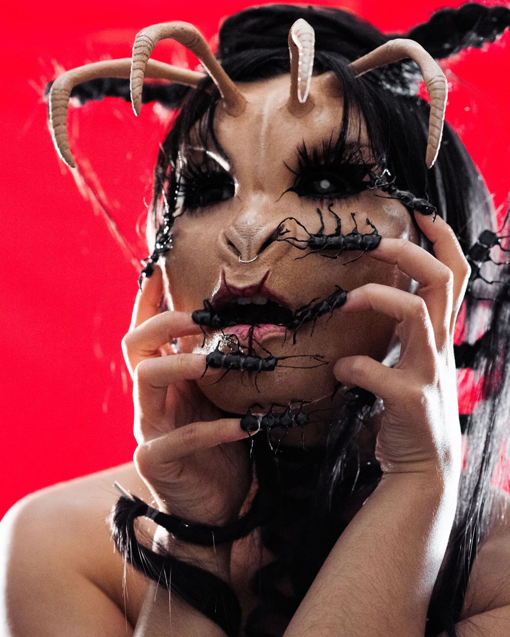 Female horror character with insect-inspired makeup and costume poses in low light with a menacing expression, captured by Chris Cornish Pho