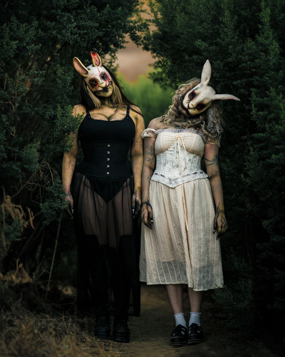 Female horror models in rabbit masks pose in a forest clearing for a stylized coven-themed shoot, captured by Chris Cornish Photography.