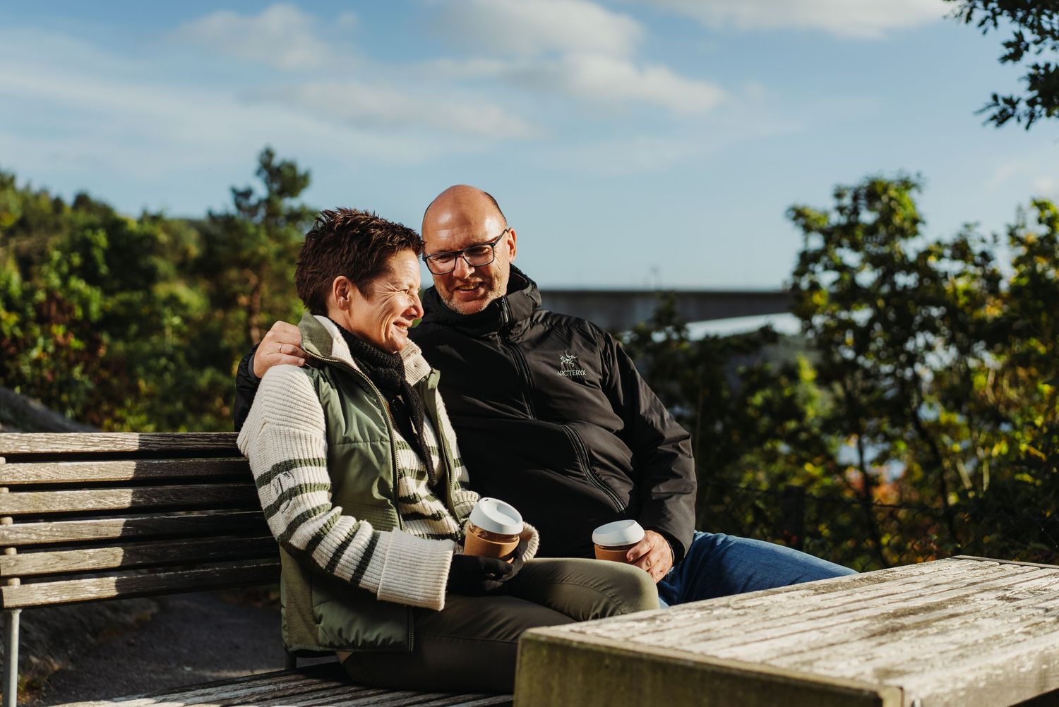Wedding couple posing together on rocky coastal shoreline.