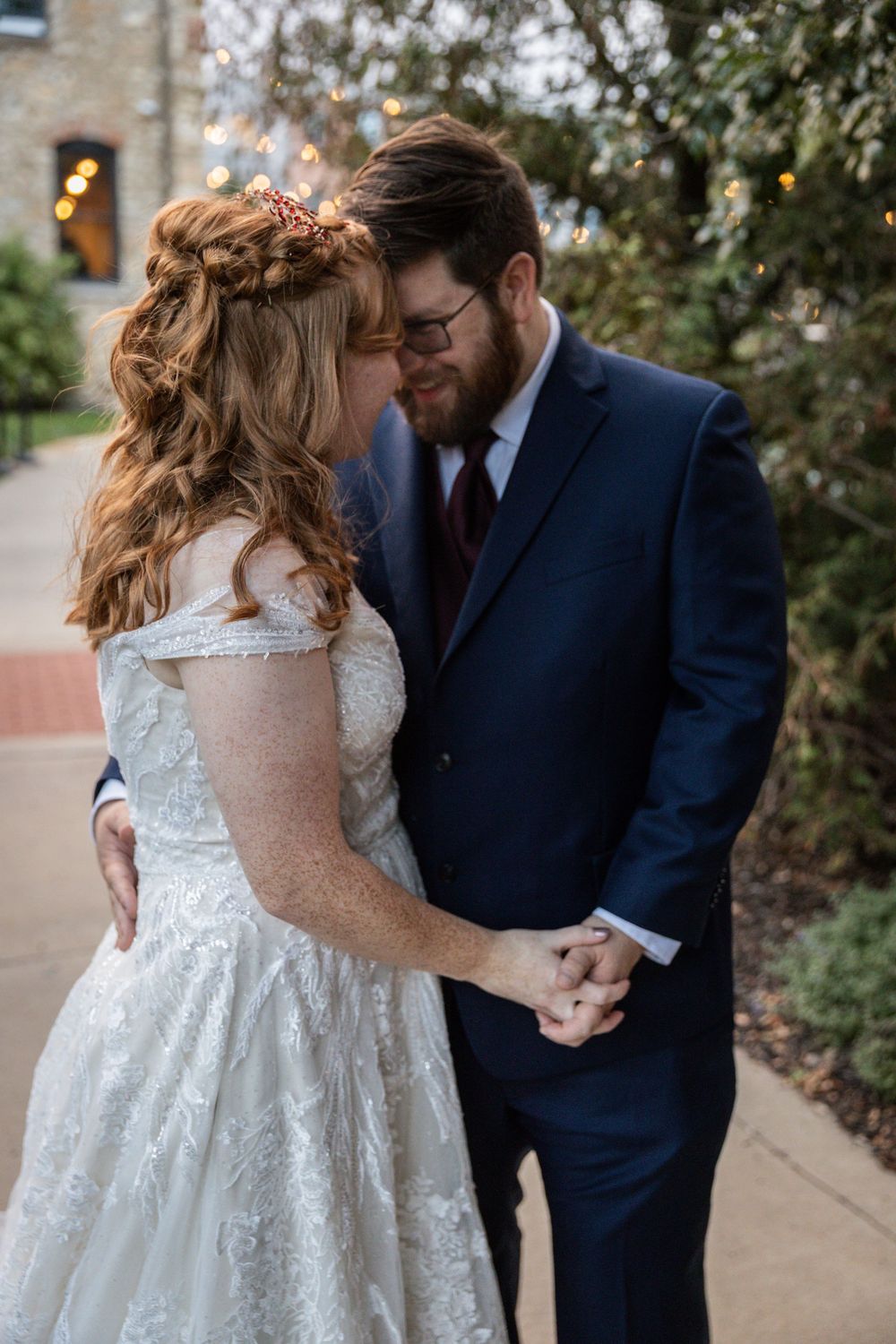 A romantic wedding couple shares intimate moments together in a garden setting during their first look photo session.