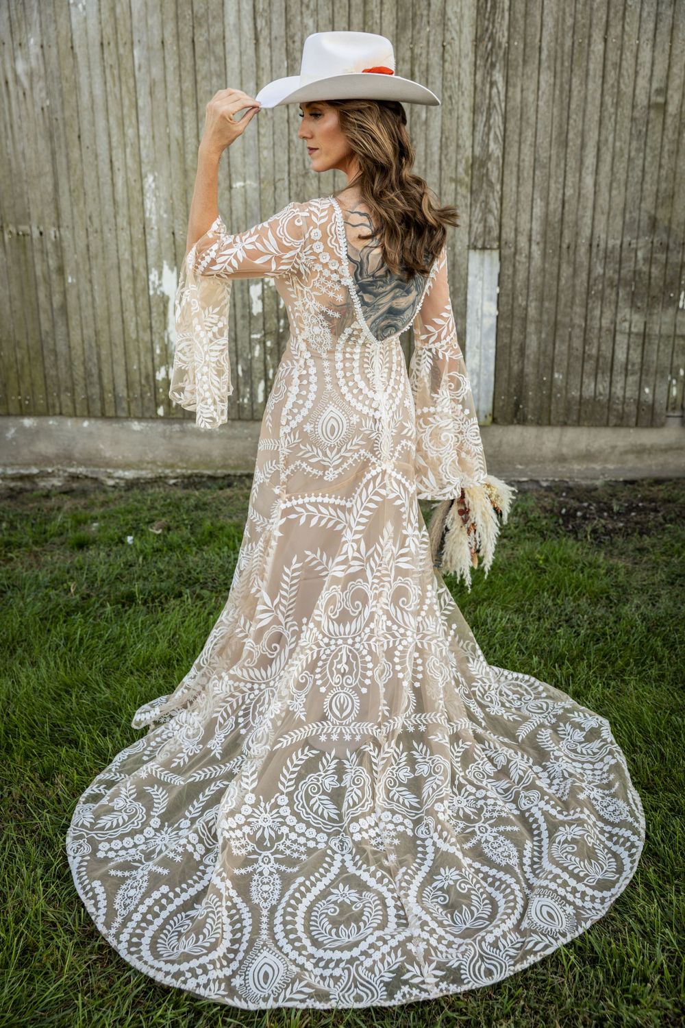 Detailed view of a bohemian lace wedding dress with intricate patterns and flowing design.