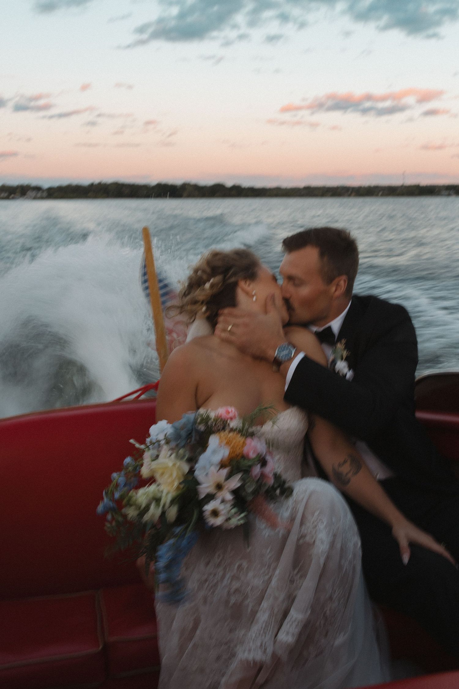 Romantic boat ride at sunset with a couple sharing intimate moments over water.