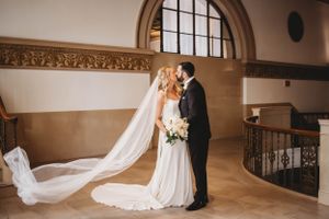 Bride and groom share intimate moment in elegant venue with flowing veil.
