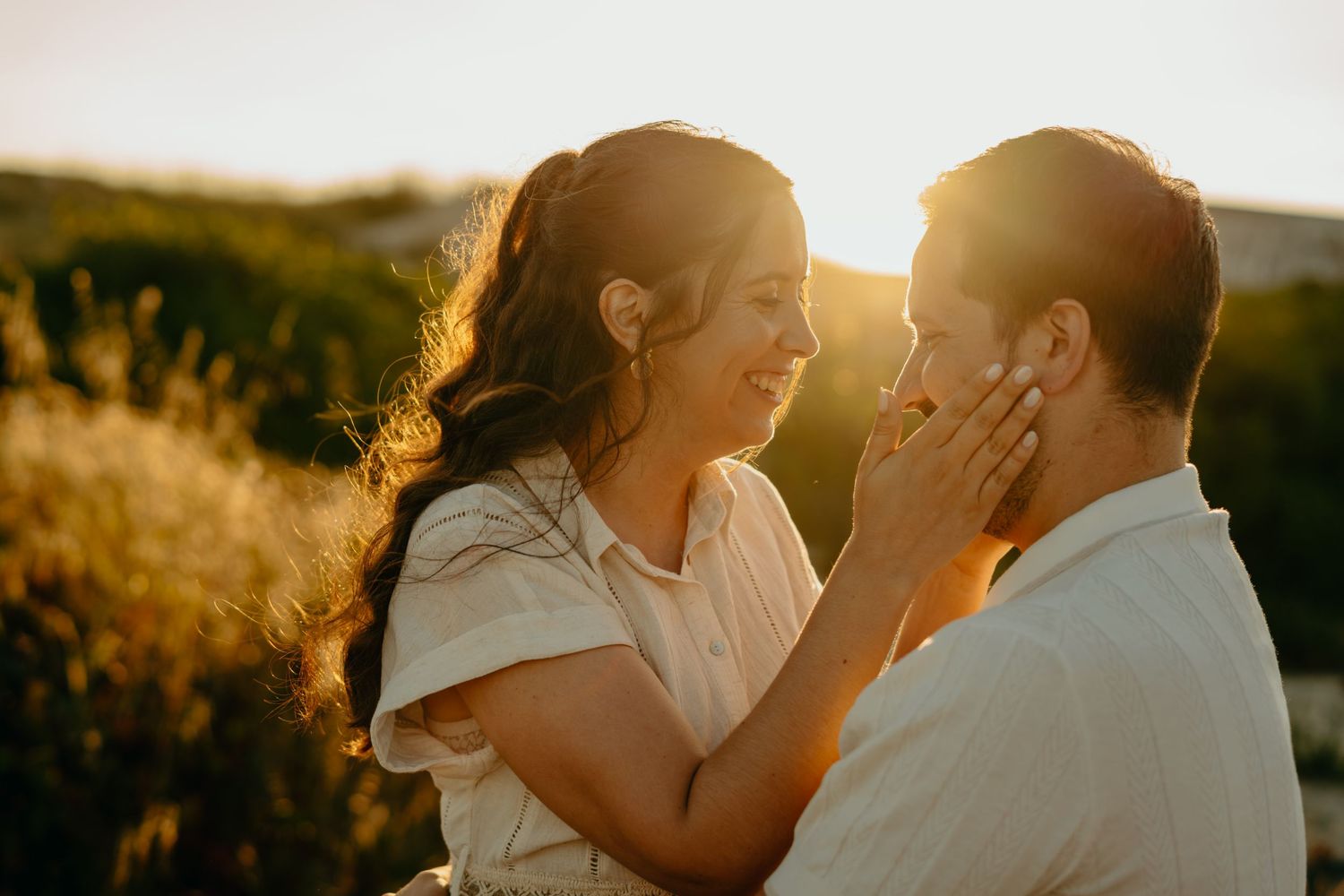 Two people share a romantic moment during golden hour on their wedding day in the mountains at sunset.
