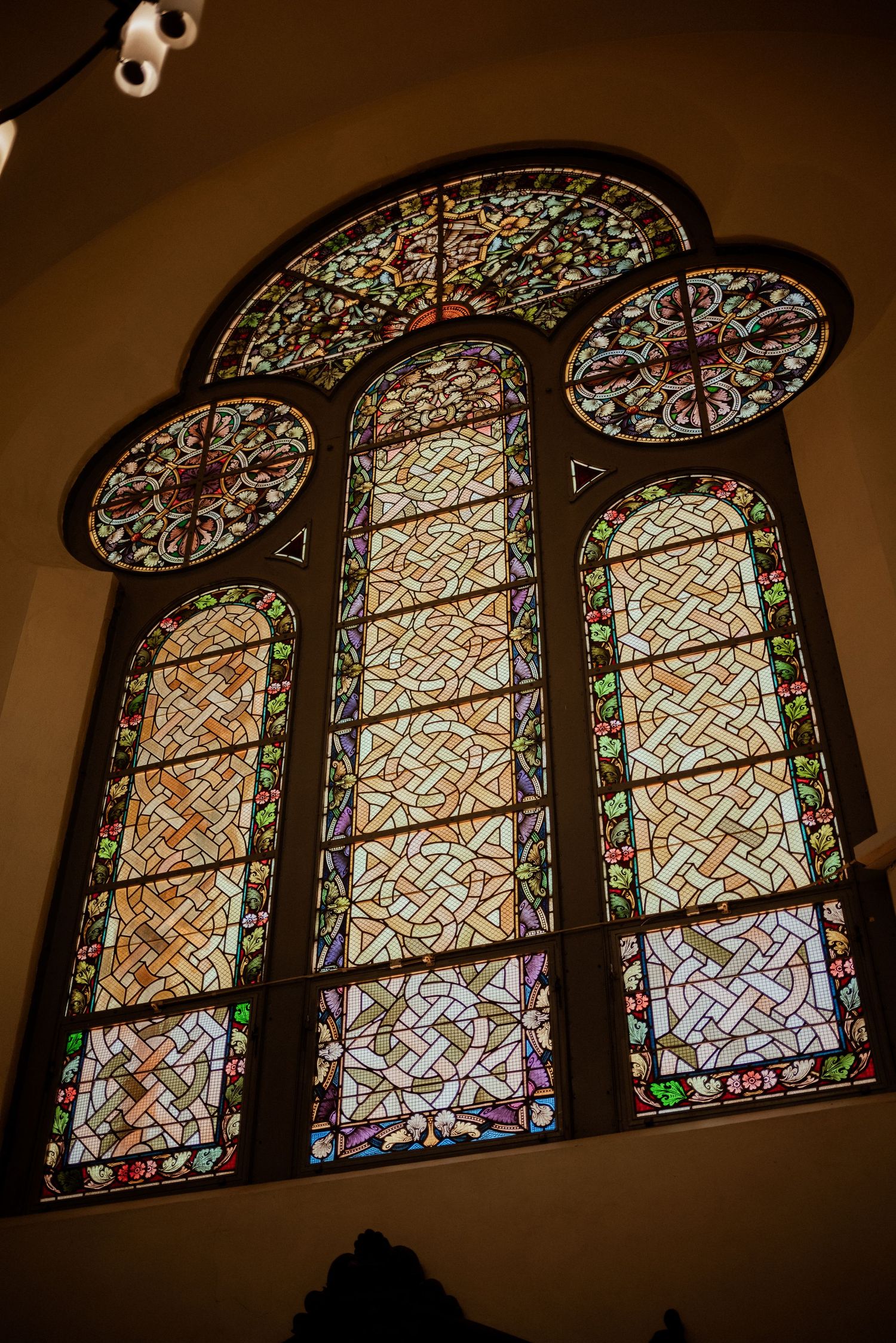 Beautiful stained glass church window with intricate geometric patterns in vibrant colors.