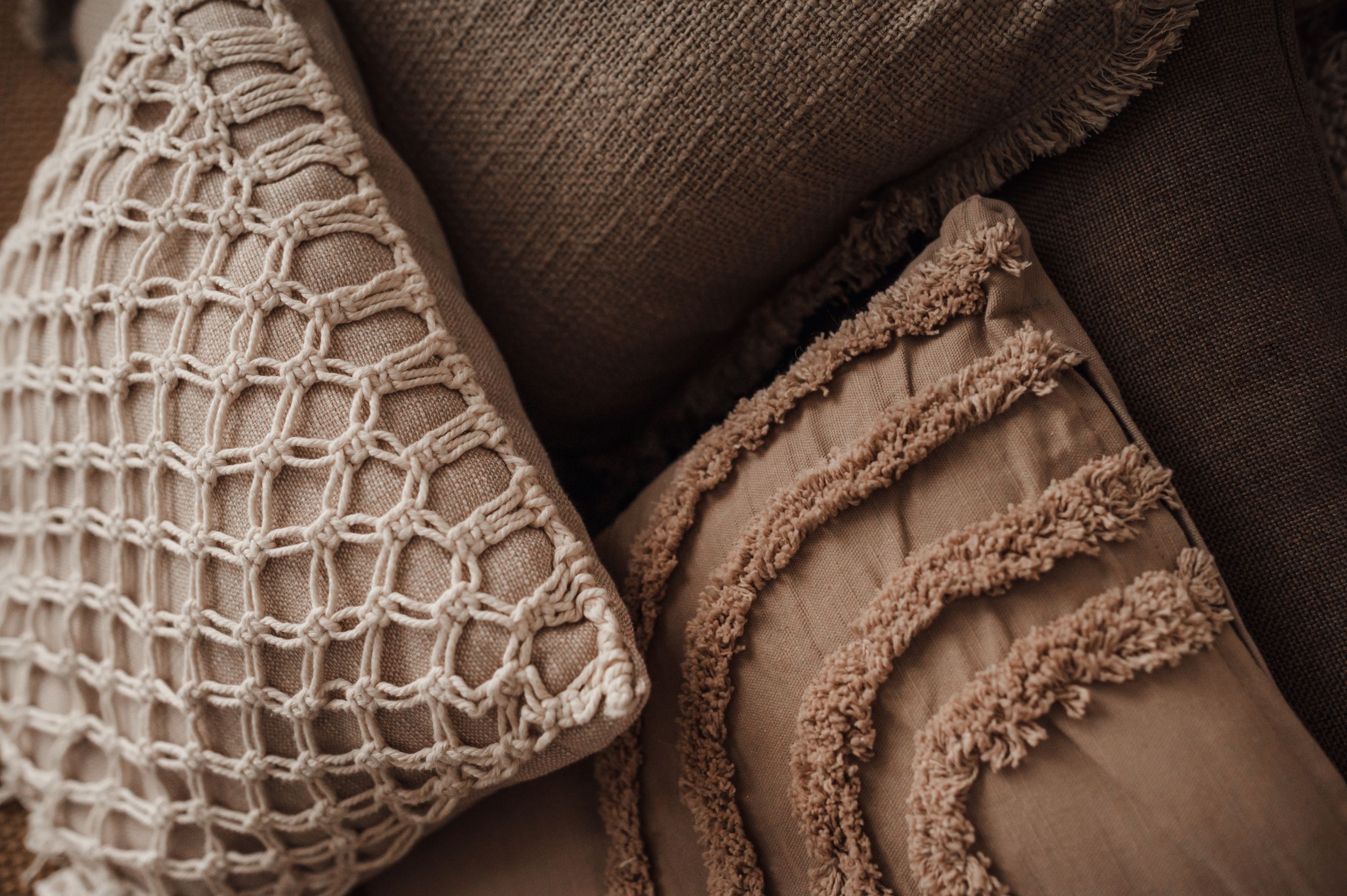 Close-up of textured decorative pillows in neutral brown tones.