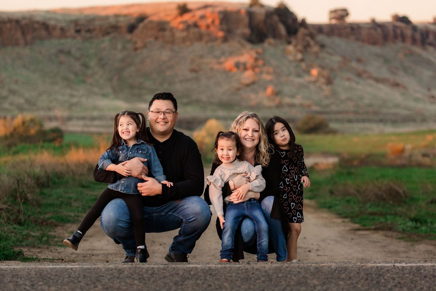 Family portrait session captured against scenic red rock formations at sunset.