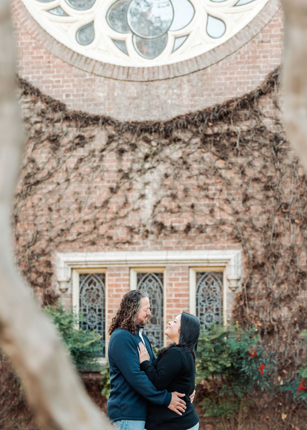 Gothic brick chapel with climbing vines provides romantic backdrop during outdoor portraits.