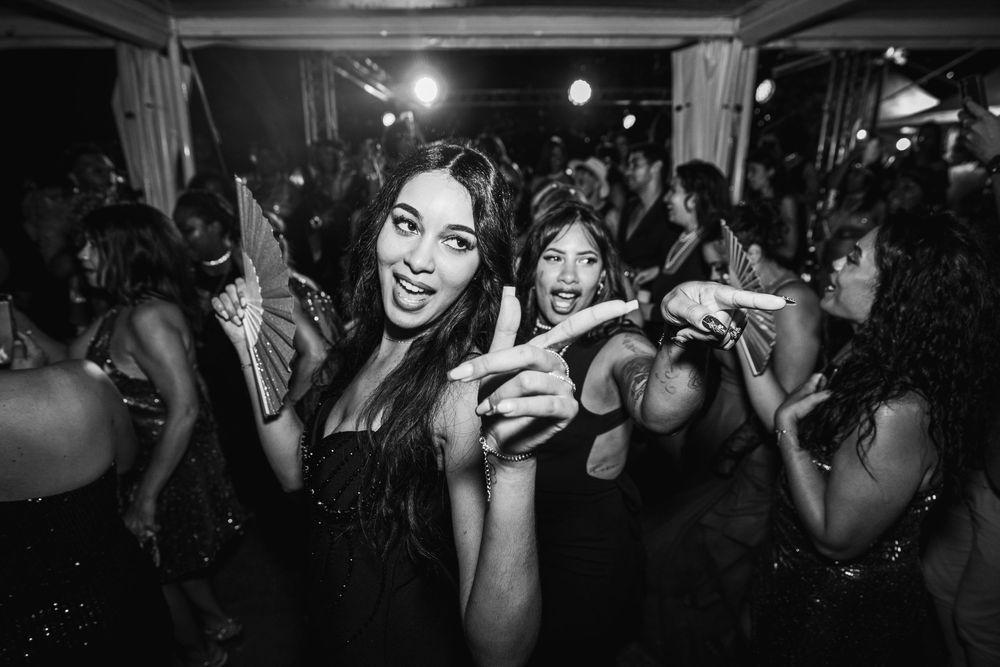 Nightclub crowd enjoying a party with people dancing and having fun in a dark, energetic atmosphere.
