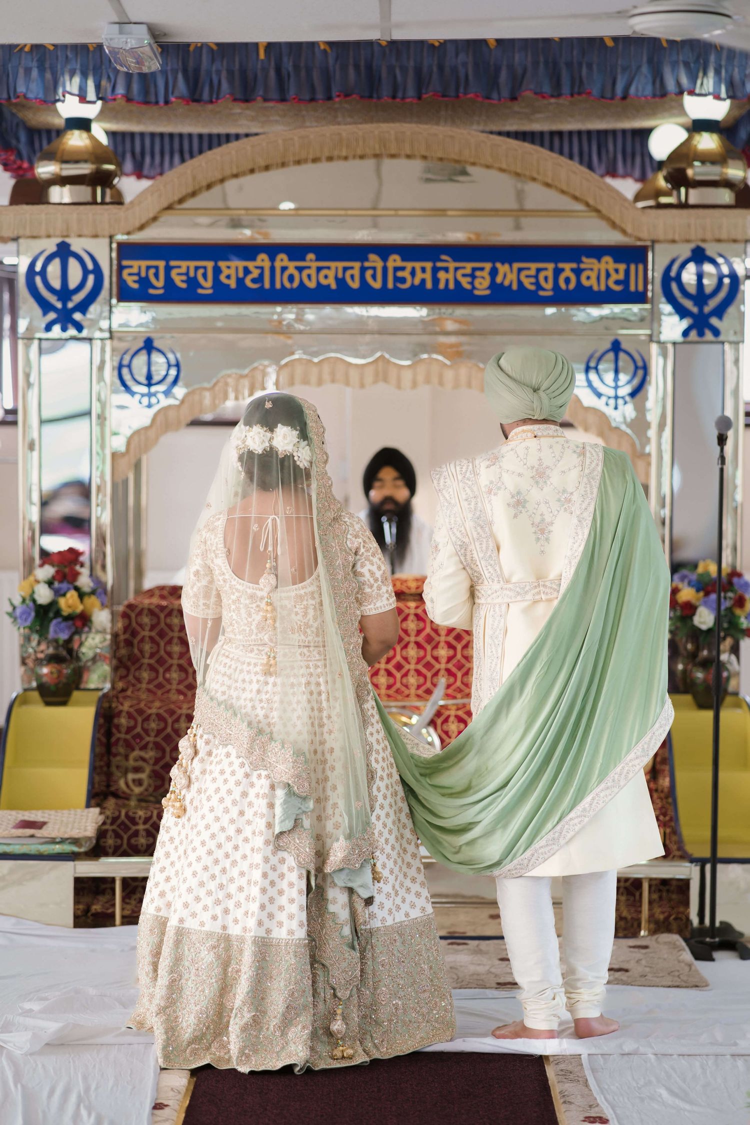 groom and bride standing before the granthi waiting for their Anand karaj