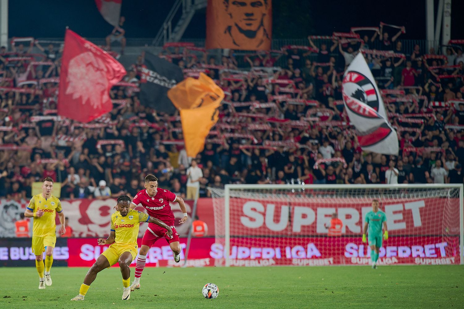 Soccer match atmosphere with colorful flags and banners waving in stadium stands.