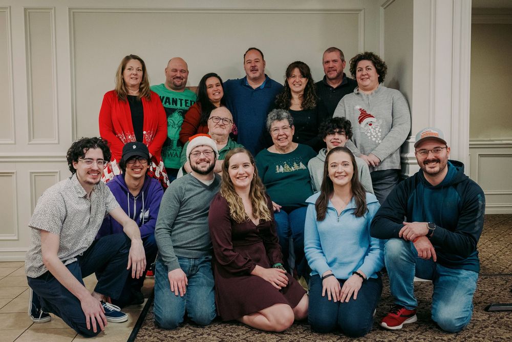A large multigenerational family poses together for a festive holiday group portrait indoors.