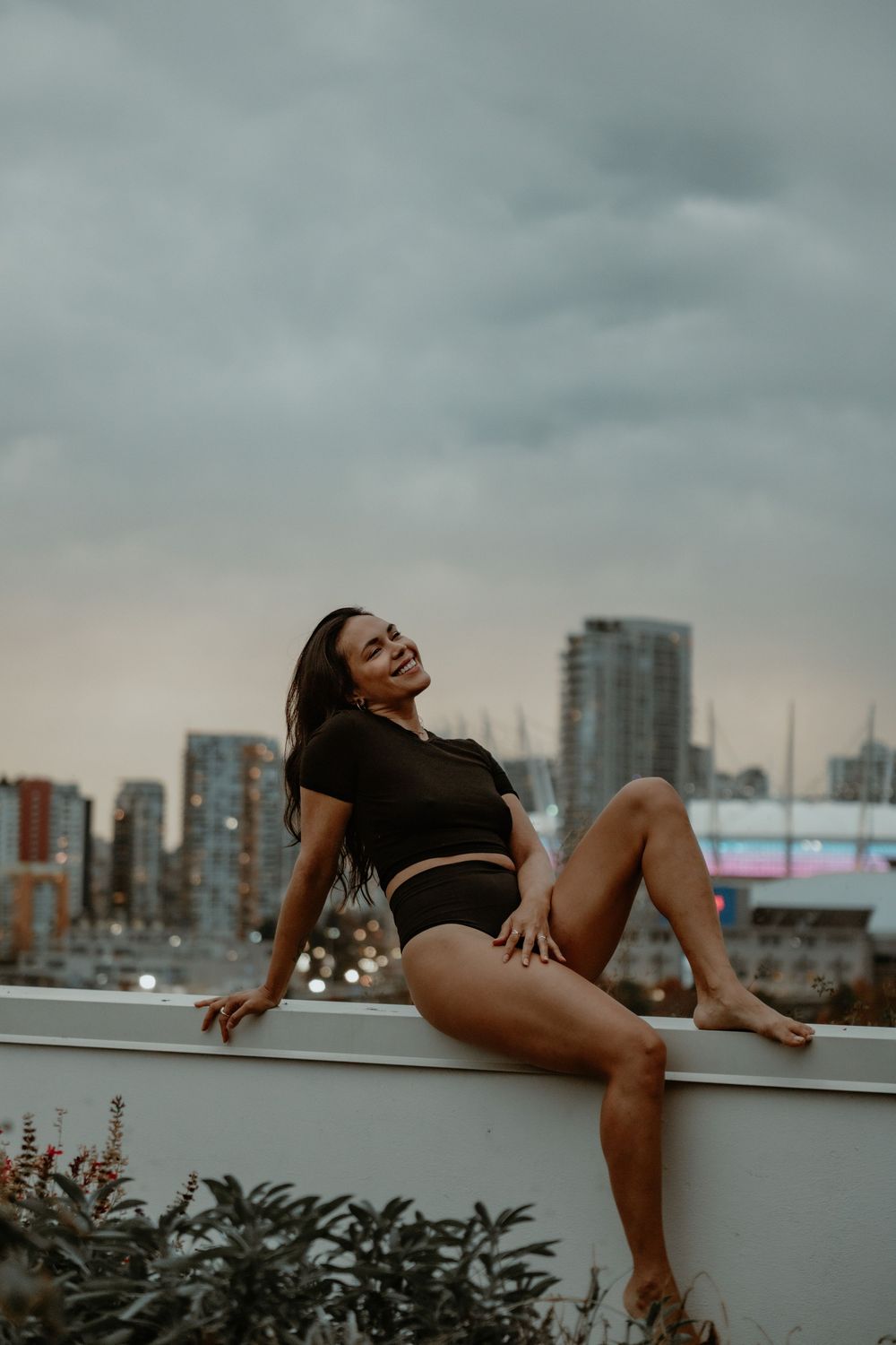 Woman posing in black lingerie on a city-view balcony in Vancouver, Canada, photographed by Sweet Confidence Boudoir