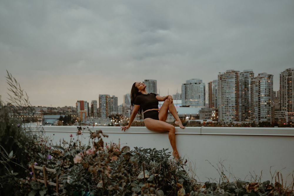 Female posing in black lingerie on a city-view balcony in Vancouver, Canada, photographed by Sweet Confidence Boudoir