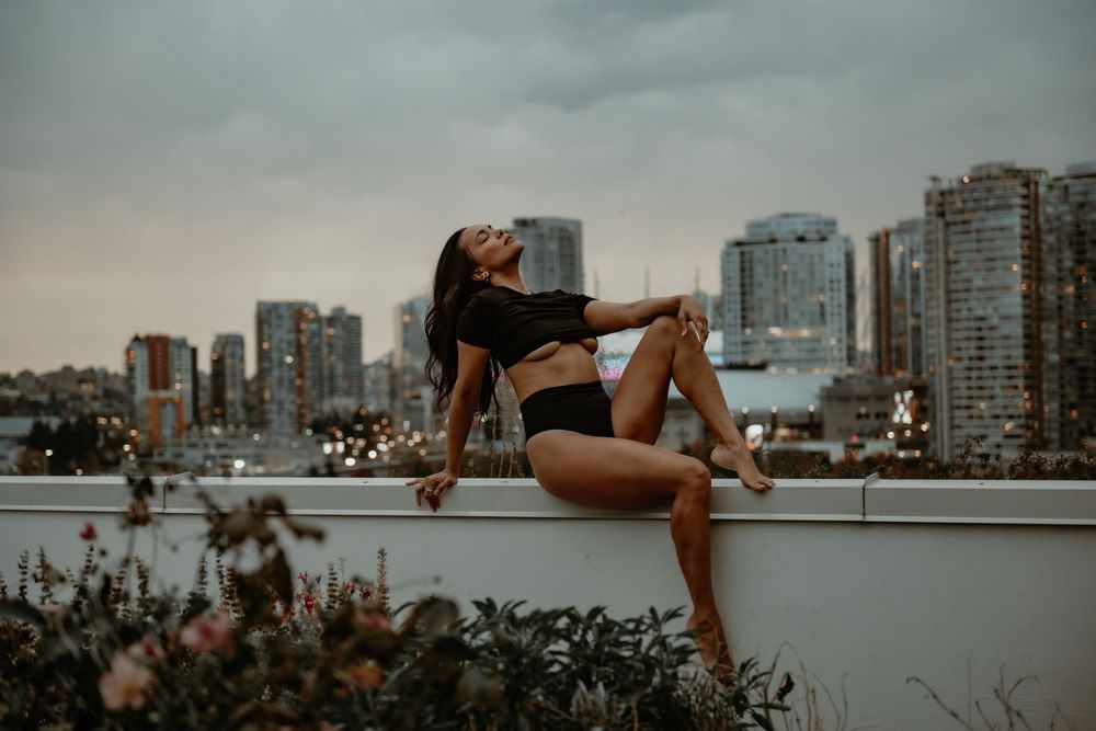 Female posing in black lingerie on a city-view balcony in Vancouver, Canada, photographed by Sweet Confidence Boudoir