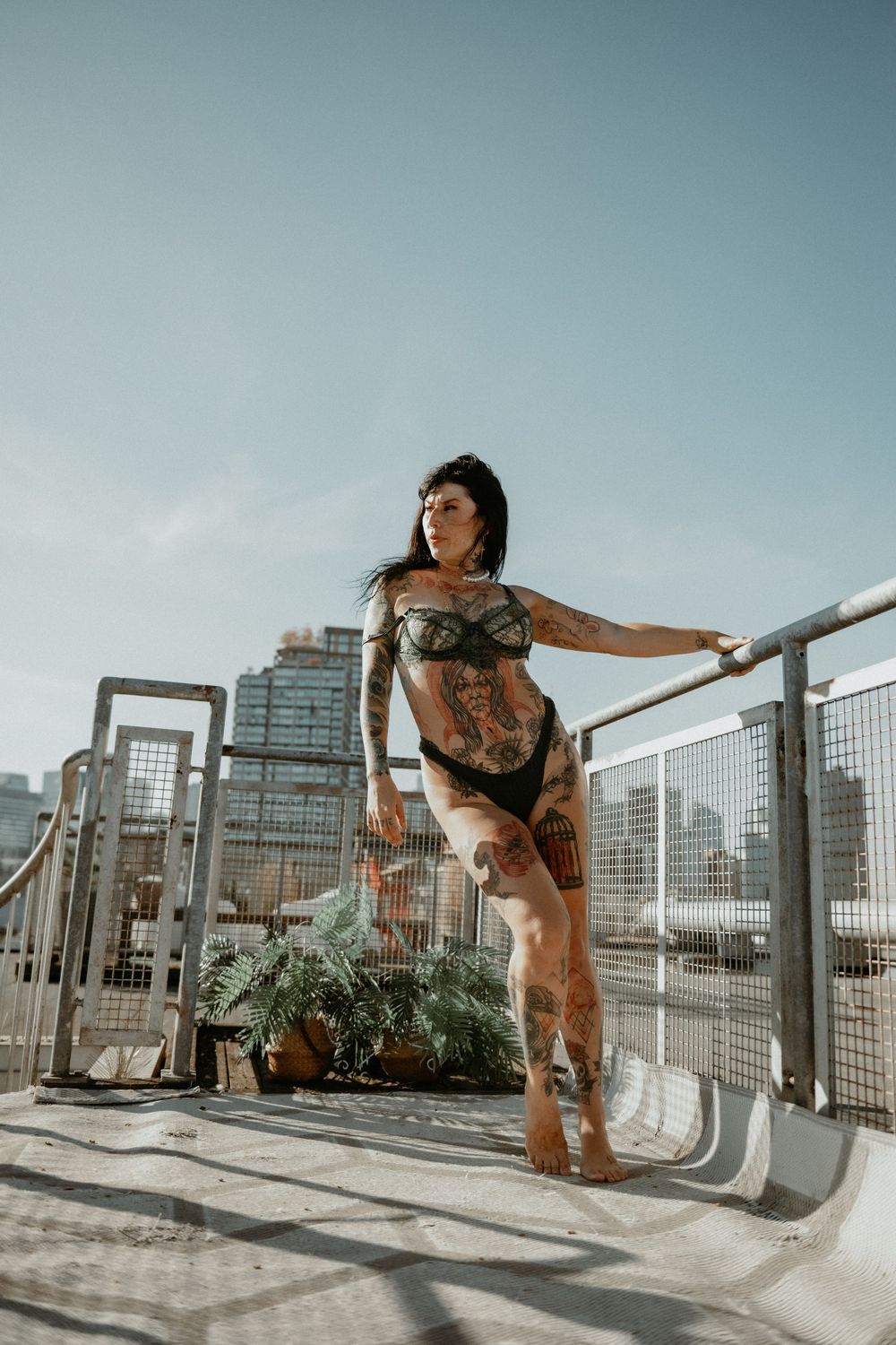 Woman posing in black lingerie on a city-view balcony in Vancouver, Canada, photographed by Sweet Confidence Boudoir