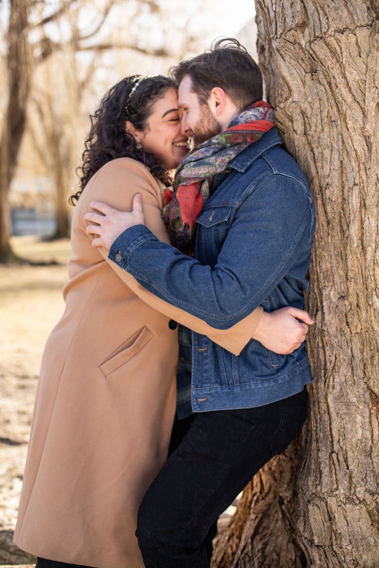 couple leans against tree and smiles, candid winter photo boston public garden