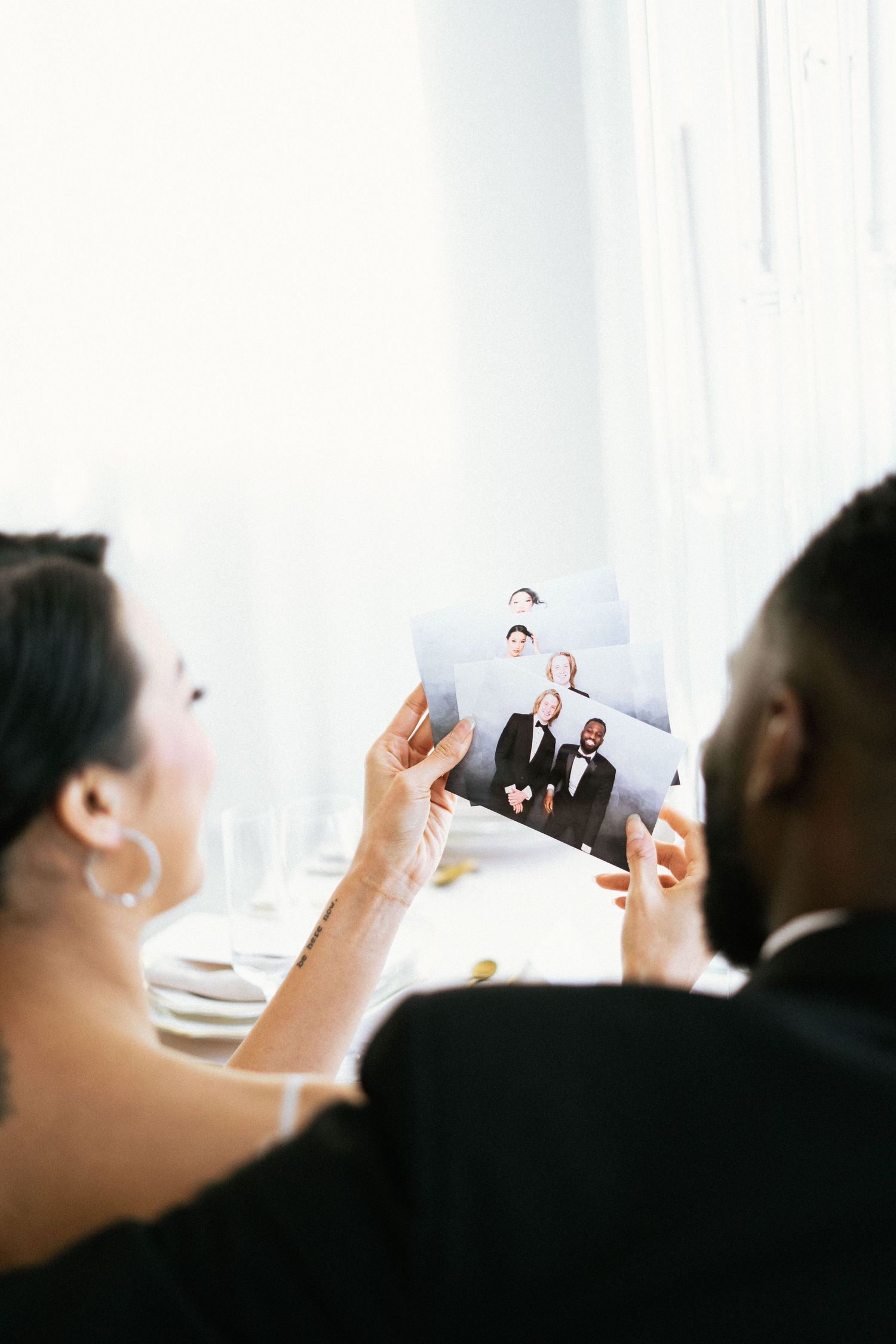 A couple looks at a photograph together during a wedding reception at a bright, elegant venue.