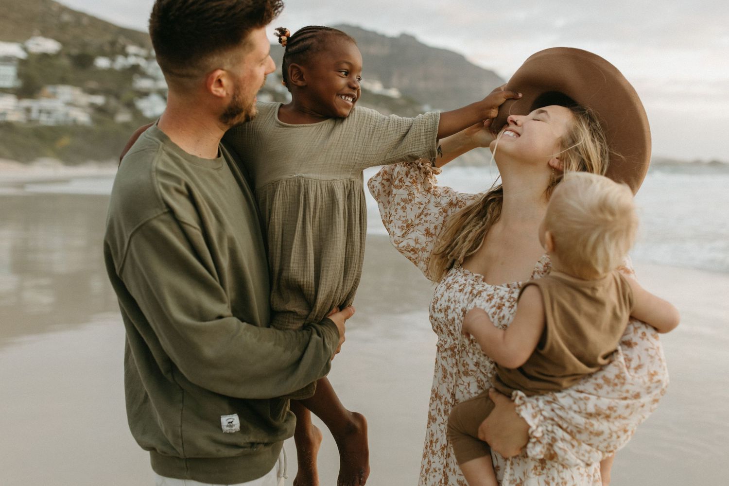 Friends sharing joyful laughter together on a cloudy beach.