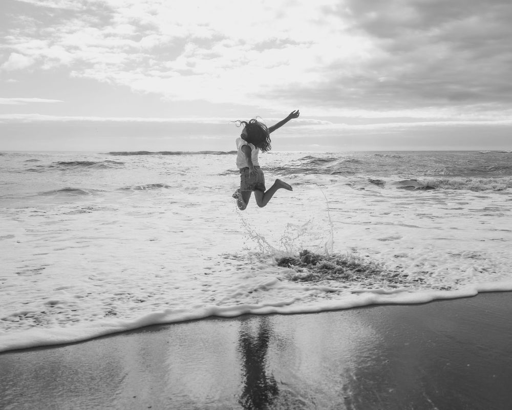 child jumping in waves on a west coast beach