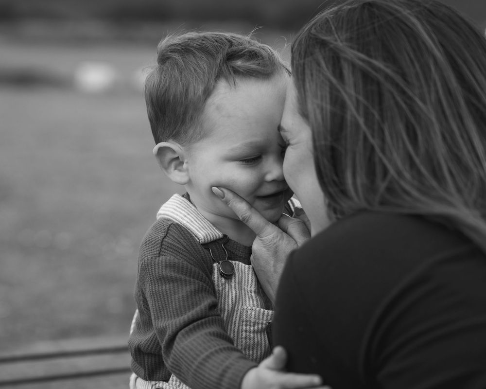 mother and toddler son squishing noses in black and white
