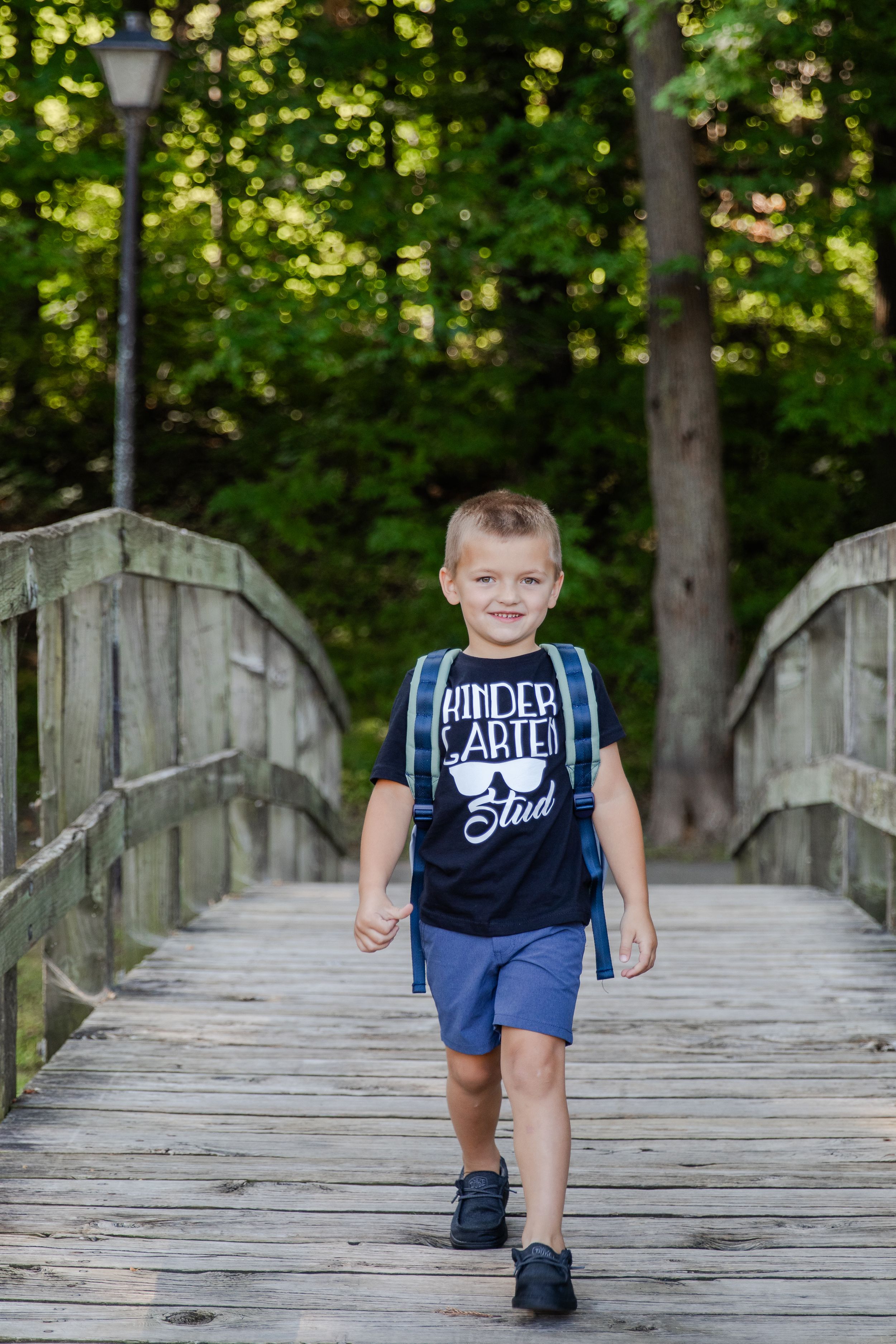 Kindergartener walking with his backpack on smiling excitedly on his first day of school.