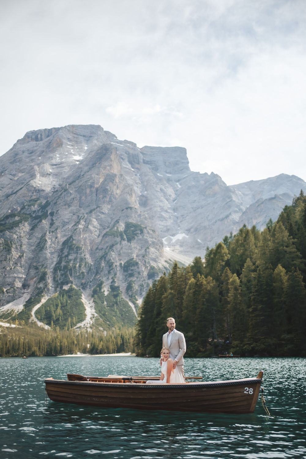 Intimate destination elopement in Italy featuring a newlywed couple sharing a quiet moment on a Lago di Braies boat.