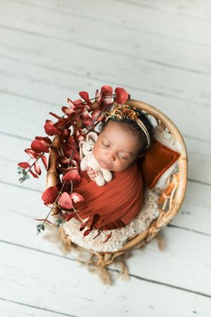Rustic wooden bowl setup with red floral arrangements and soft fabric wrapping.