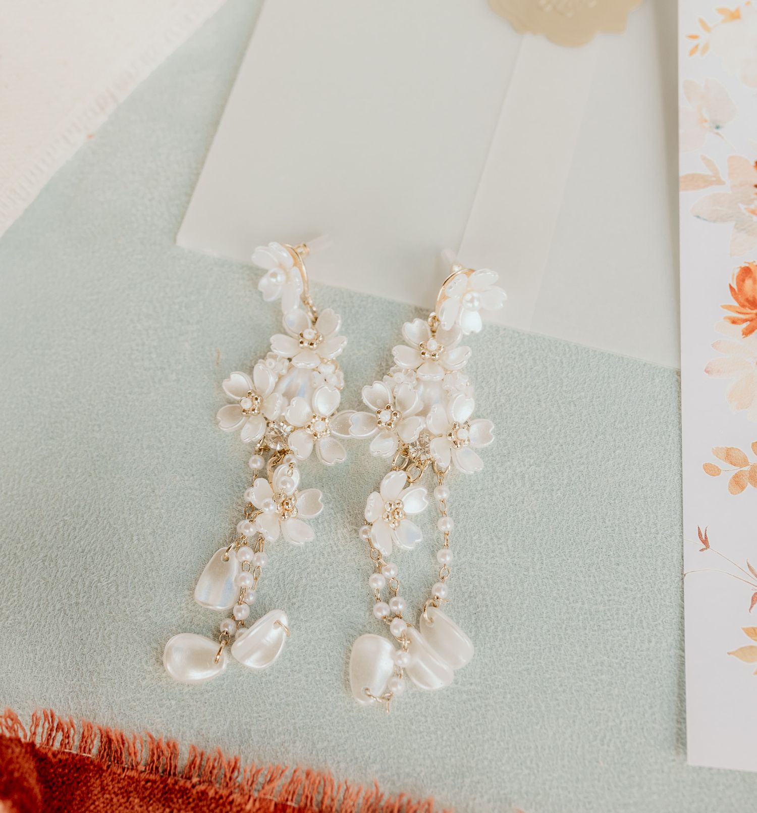 Delicate pearl and crystal bridal earrings displayed on a light background.