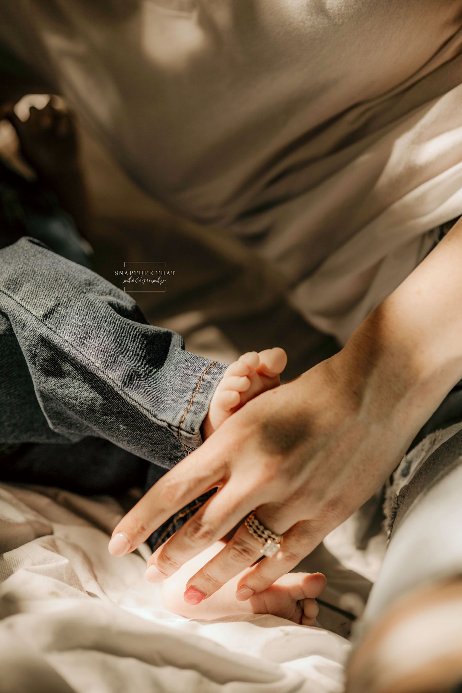 Close-up detail shots of hands gently holding and adjusting denim fabric against a light background.