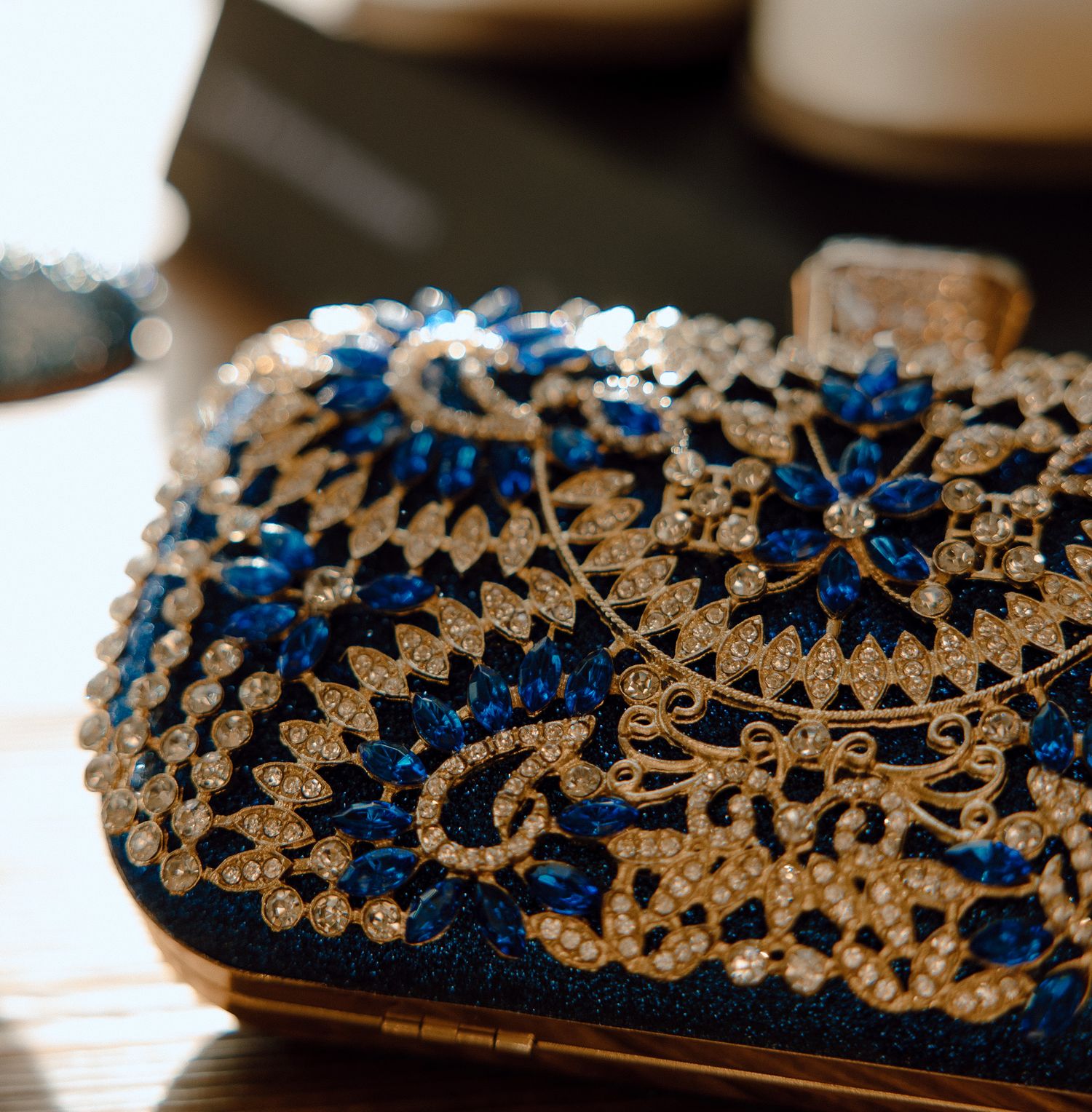 Ornate blue and gold beaded clutch purse with intricate floral pattern detail.