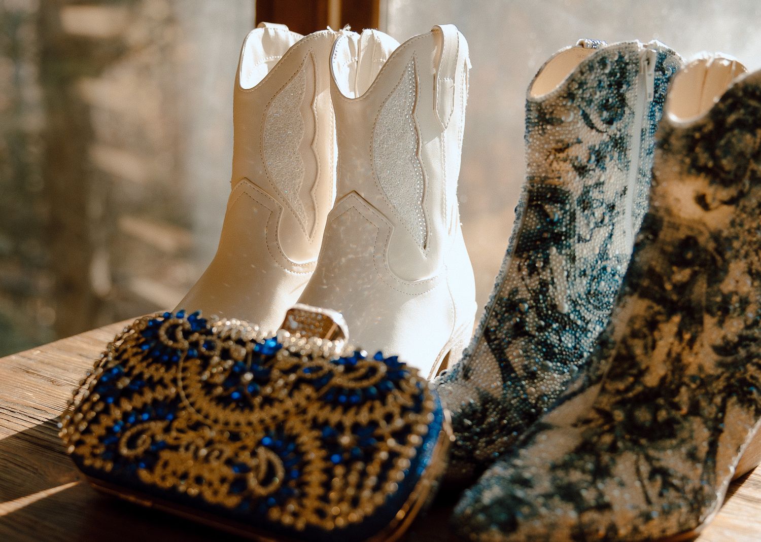 White and patterned blue cowboy boots displayed with matching beaded clutch.