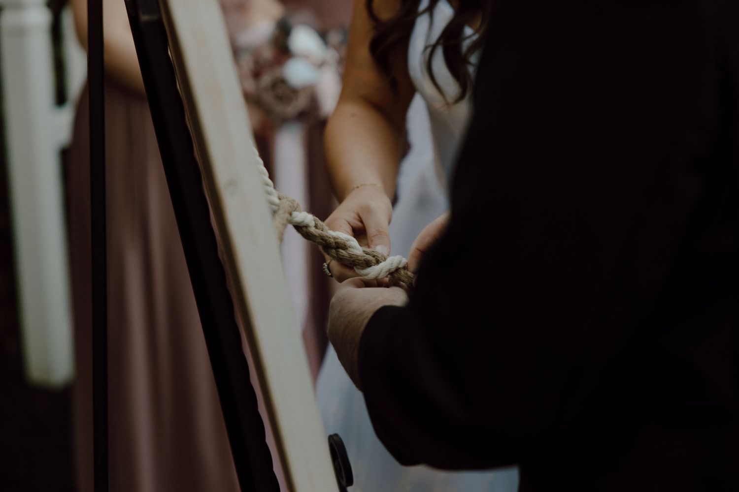 Elegant wedding dress details being prepared in soft natural light.