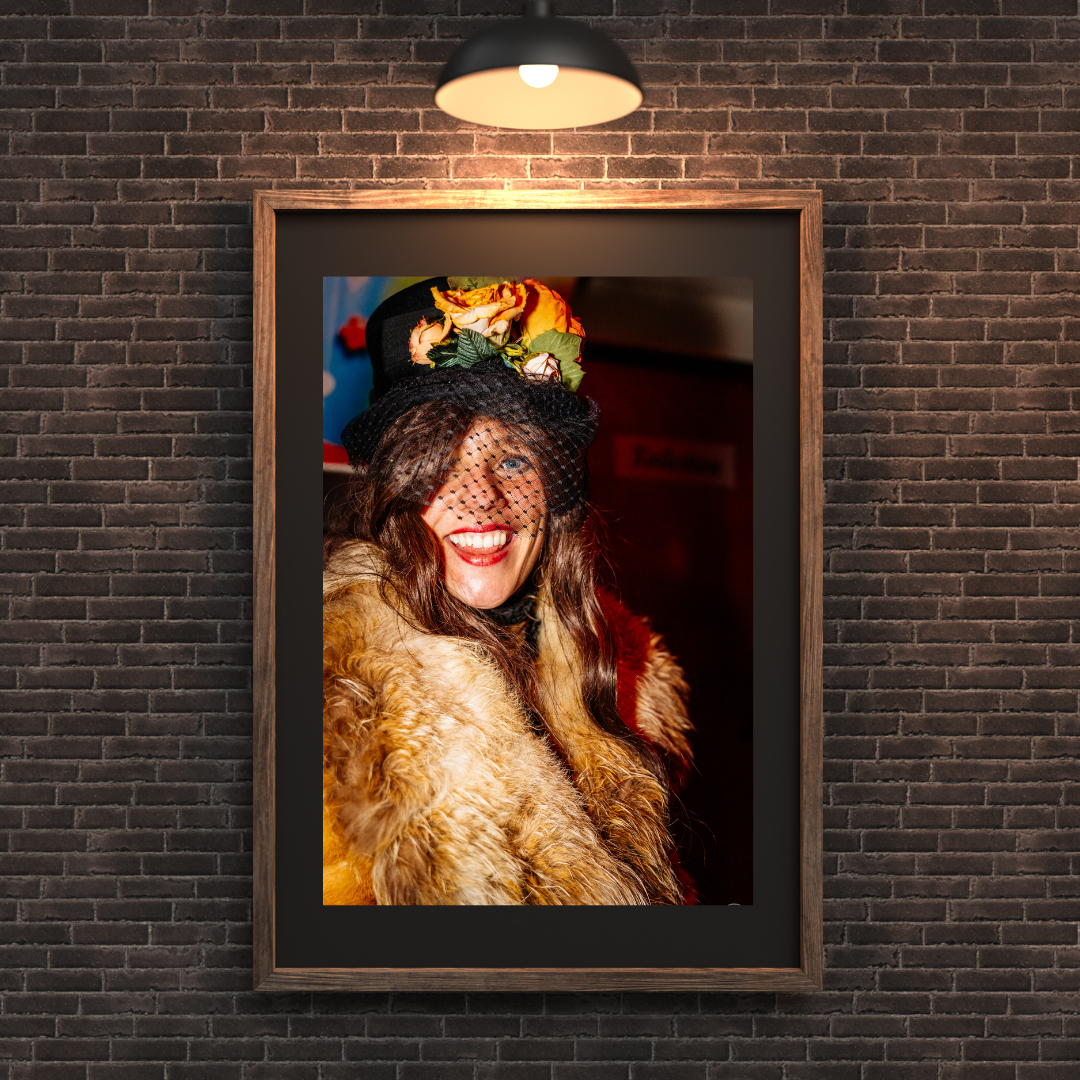 Framed photo print of a woman in a carnival costume displayed on a brick wall. Vivitu wall art.