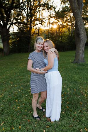 Two people embracing outdoors at sunset with trees in background. Family session in Lake Geneva, Wisconsin.