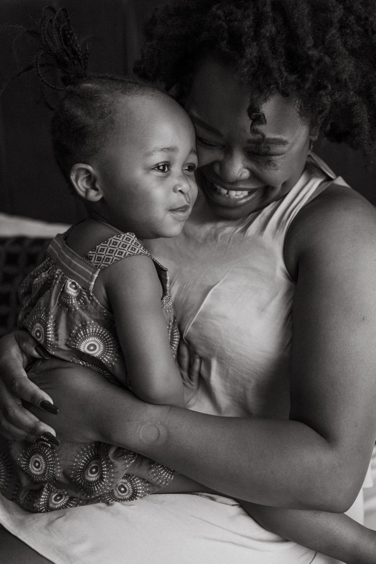 A tender black and white photo series showing intimate moments between parent and child in bed.
