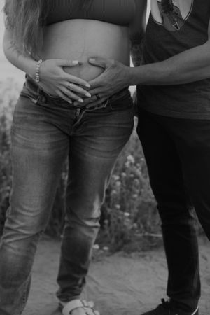 Black and white photo series showing progression of a pregnancy through jeans-clad belly silhouettes.