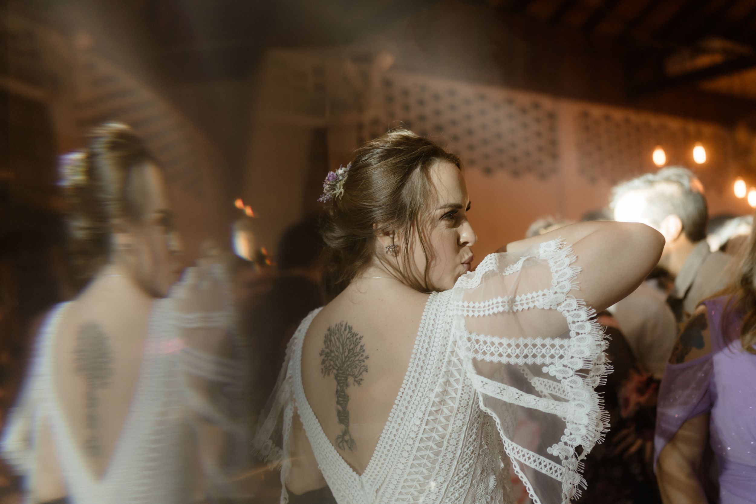 Motion blur of people dancing at a formal event in white dresses.