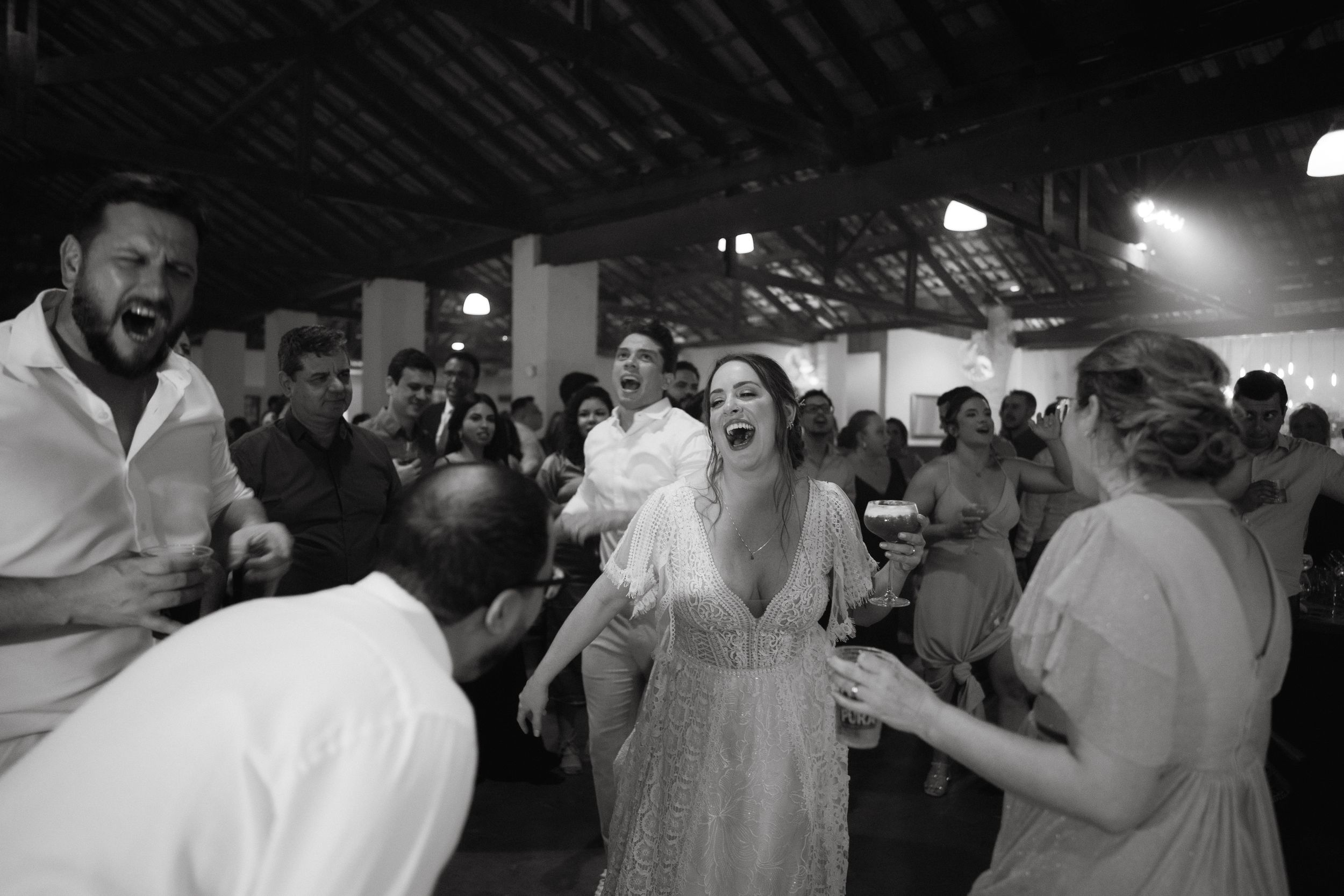 Black and white photo capturing energetic dancing during a lively wedding reception.
