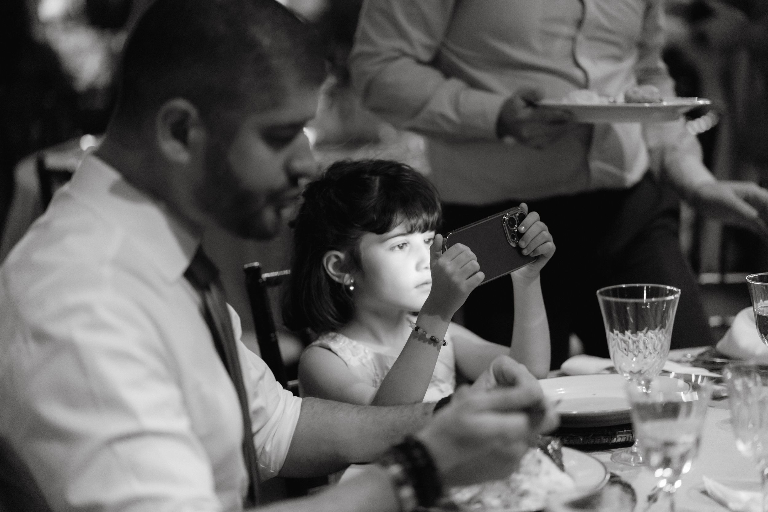 People dining at a restaurant table with wine glasses.