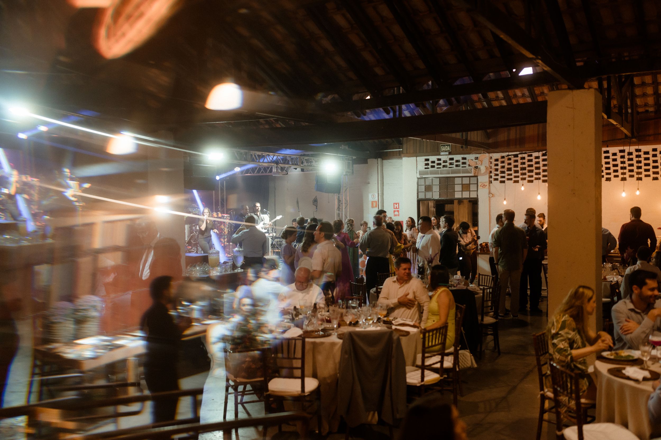Wide shot of a dimly lit restaurant interior with diners at tables.
