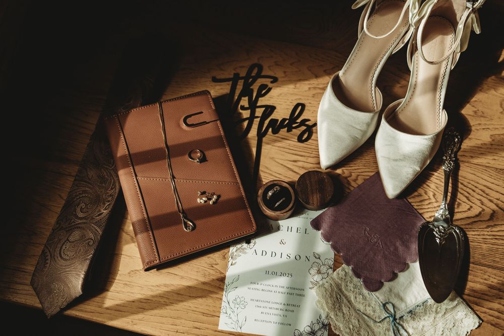 A collection of leather wallets and accessories arranged on a wooden surface with natural lighting.